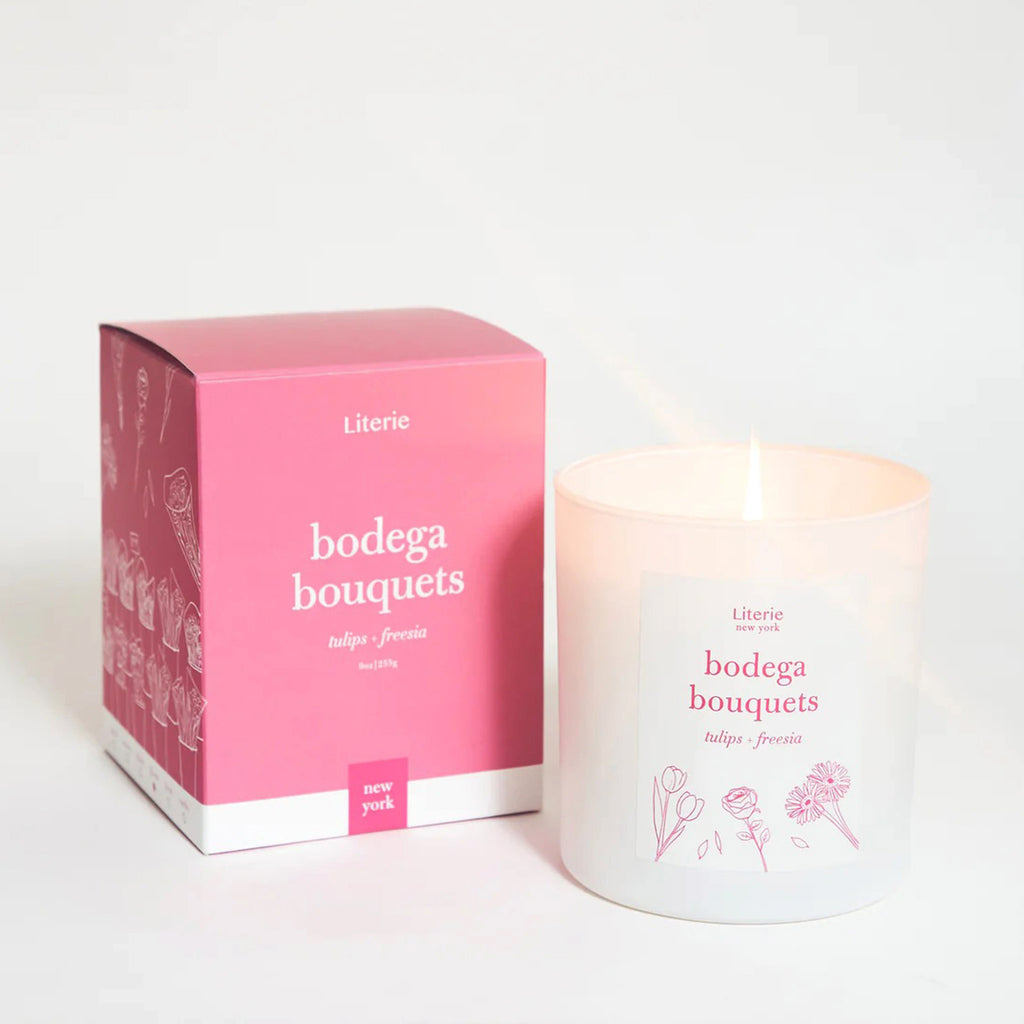 Literie 9 ounce Bodega Bouquets tulips and freesia scented soy and coconut wax blend candle in matte white glass tumbler with illustrated label and matching pink gift box.