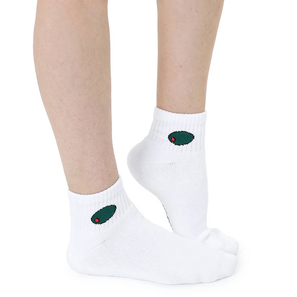 White ankle socks with green olives at the top worn by a person on a white background.
