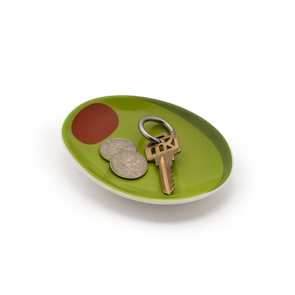 Green oval tray with a key and coins on a white background.