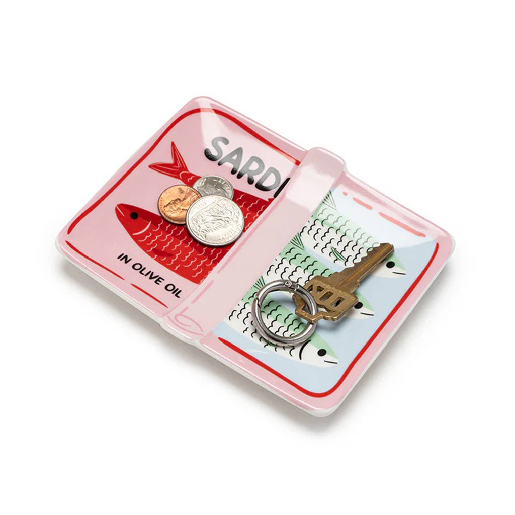 Ceramic trinket tray painted to look like a partially opened sardine can with coins and keys, overhead view on a white background.