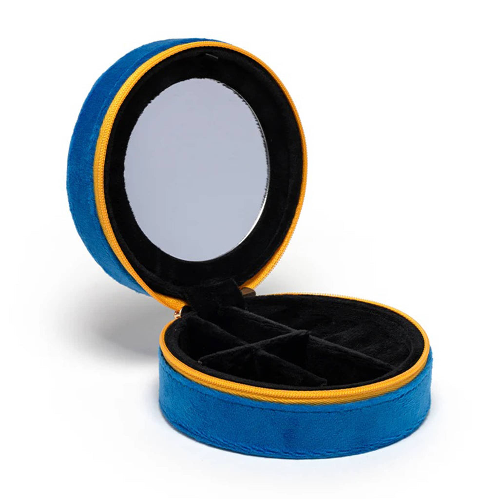 Round blue velvet jewelry case opened to show mirror and black velvet lining inside, on a white background.