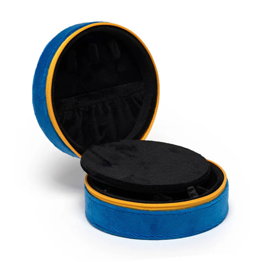 Round blue velvet jewelry case opened to black velvet lining inside, on a white background.