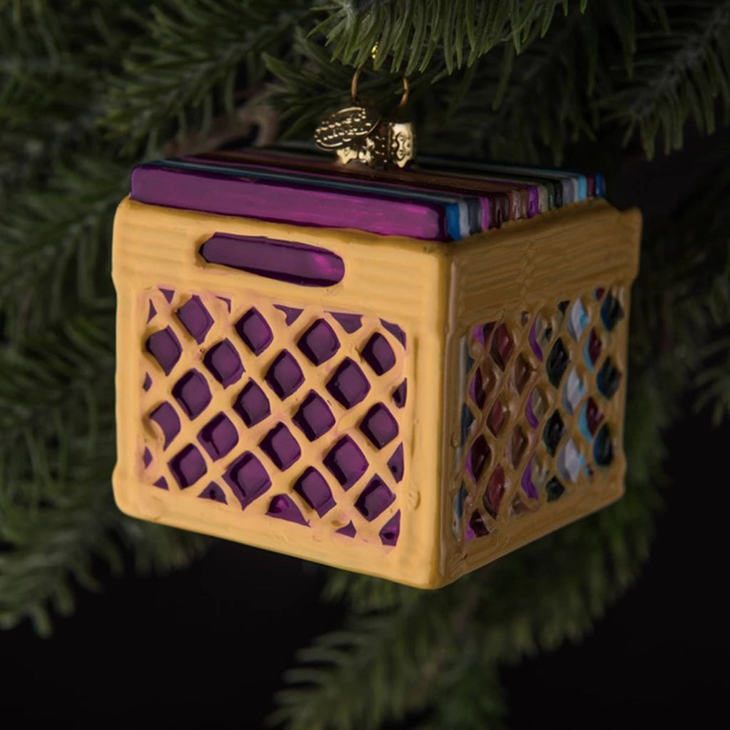 Love and Victory record crate hand-blown, hand-painted glass holiday ornament hanging on an evergreen tree.