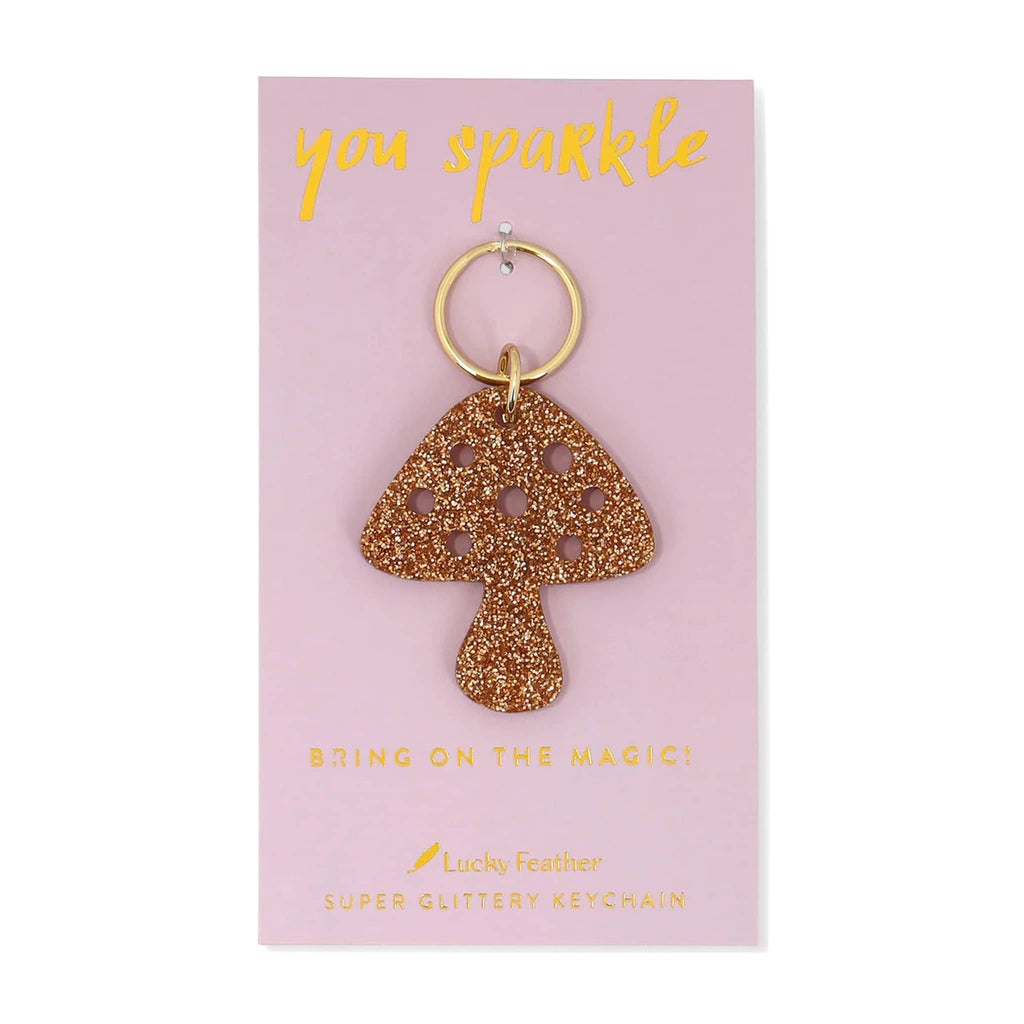 Glittery mushroom keychain on a pink card with 'you sparkle' text.