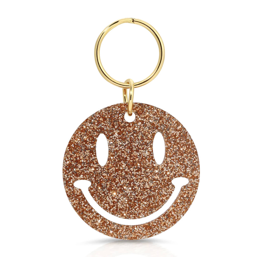 Gold glitter smiley face keychain with gold ring on a white background.