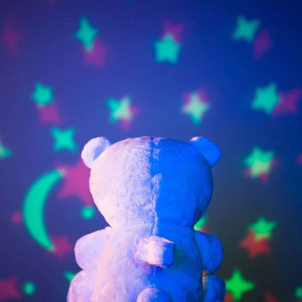 Lumieworld Lumipets Bear Nursery Sound Soother with night light, white plush bear, back view with star and moon shapes projected in front of bear.