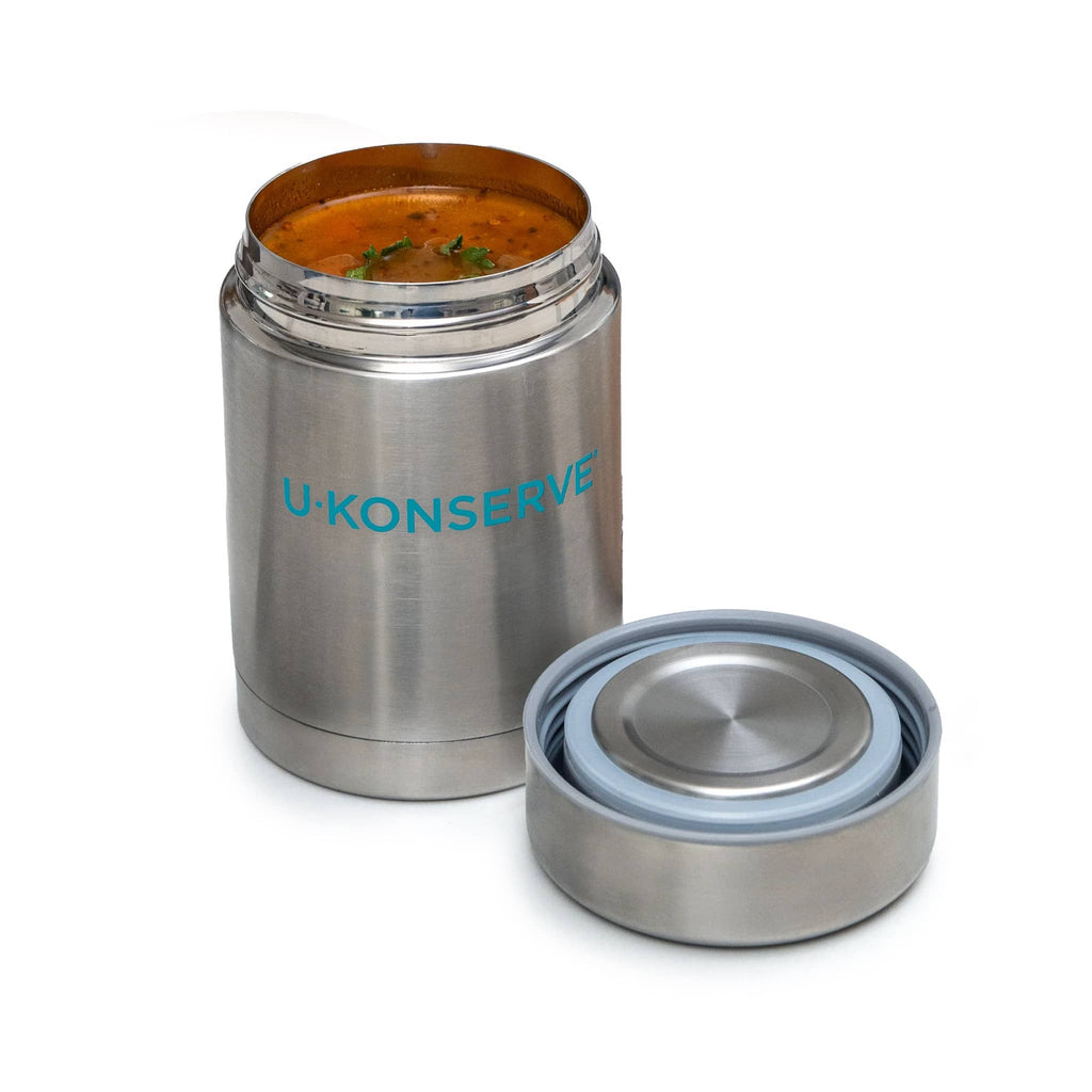 Insulated stainless steel food container with lid and 'U-Konserve' branding, lid off and filled with soup, on a white background.