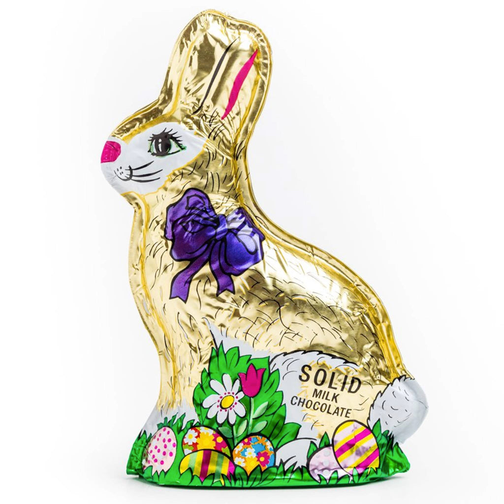 Madelaine 6 ounce decorative foil wrapped sitting rabbit with grass and easter eggs with purple bow solid milk chocolate bunny.