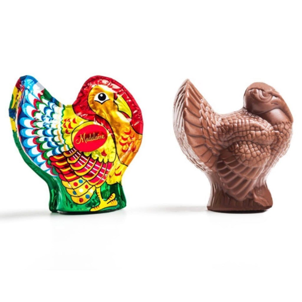 Milk chocolate turkey in foil wrapping and unwrapped, on a white background.