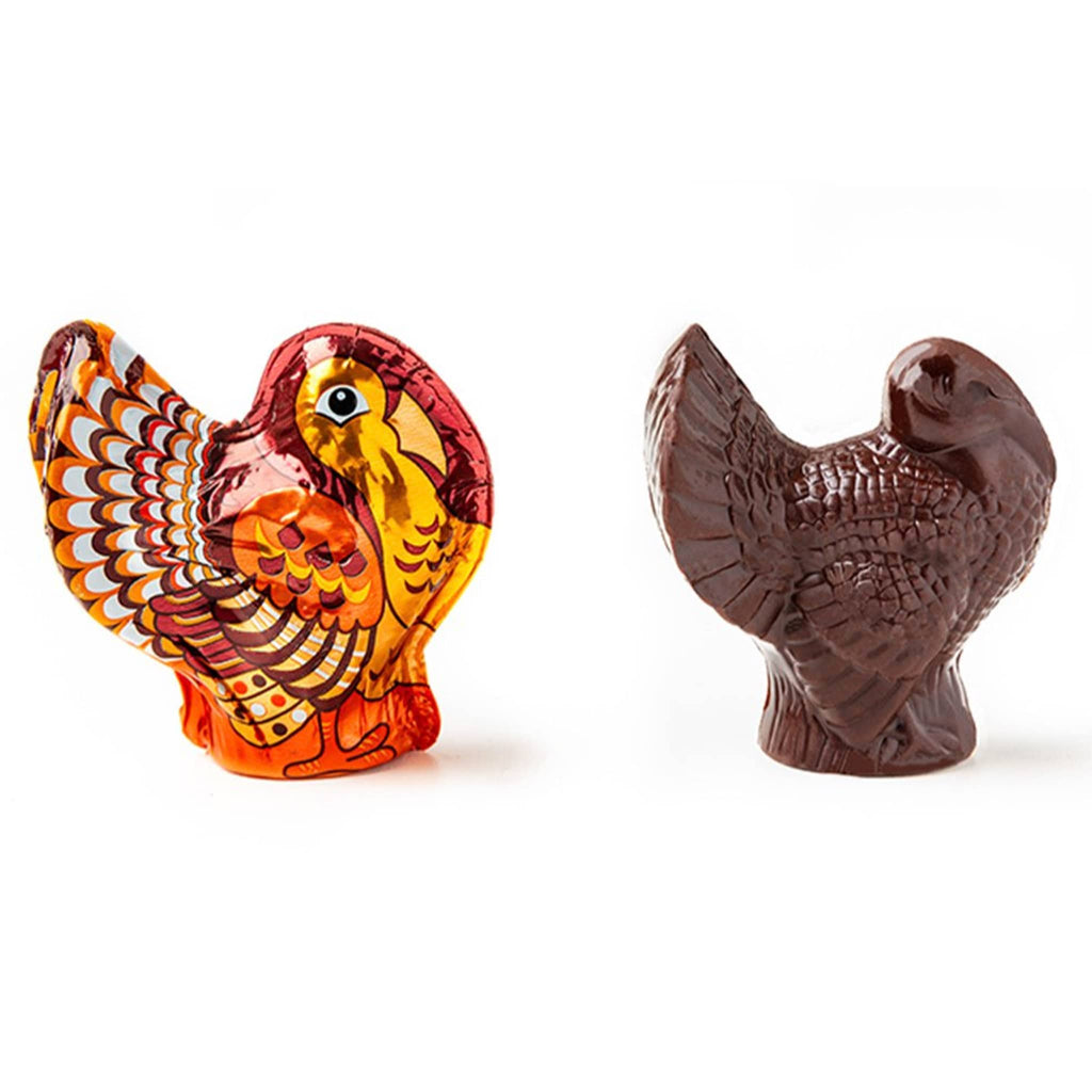 Dark chocolate turkey in foil wrapping and unwrapped, on a white background.