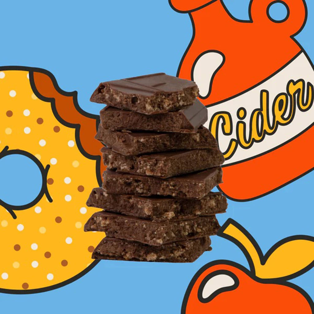 Stack of chocolate bar squares with a colorful background featuring a donut, apple, and cider bottle.