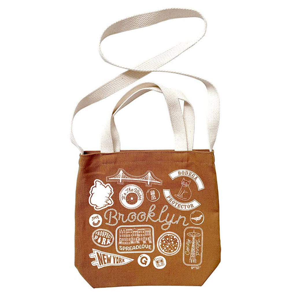 Brown tote bag with white Brooklyn graphics and text, with white webbed handles and shoulder strap, on a white background.