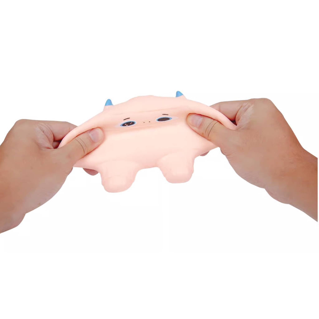 White squishy yeti being pulled between two hands on a white background.