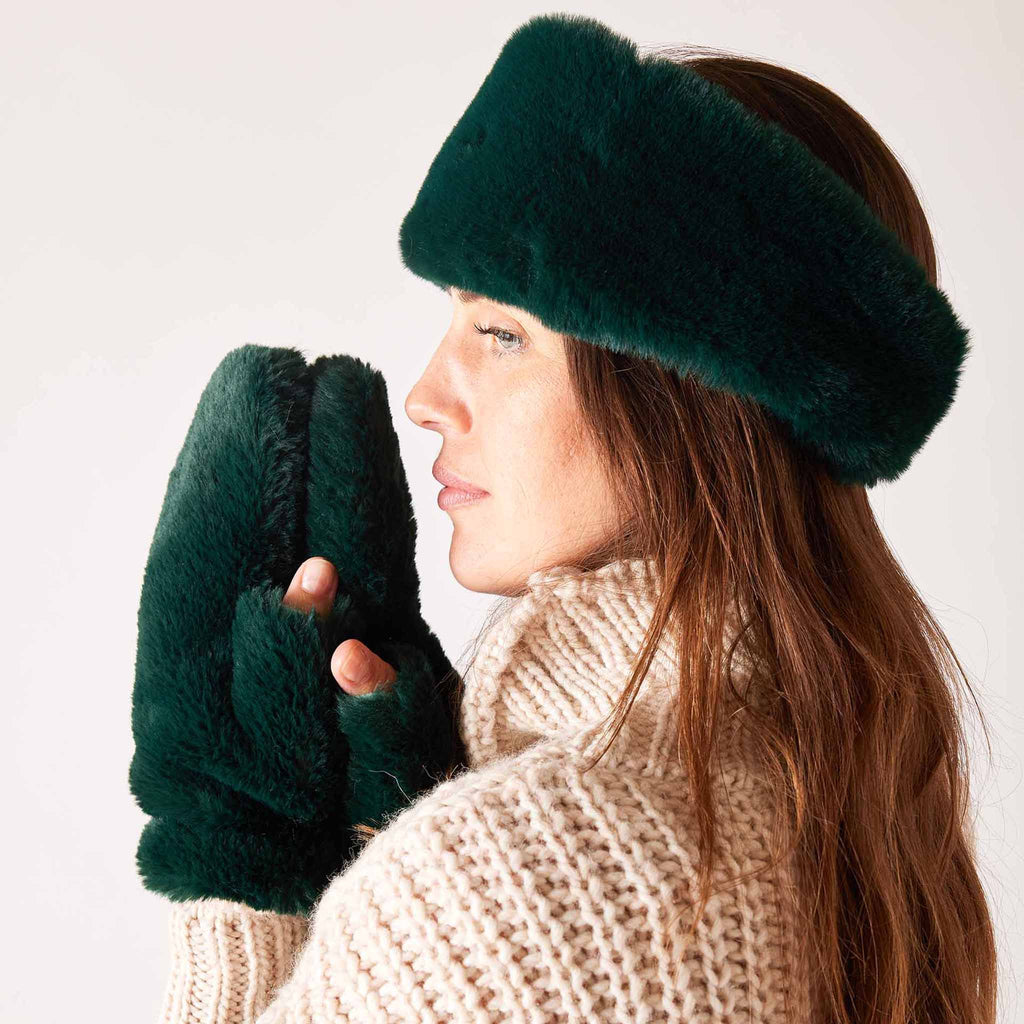 MERSEA women's pine green cozy cabin faux fur mittens on model with matching headband.