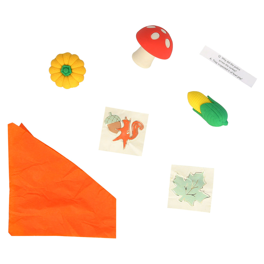 Meri Meri Turkey Surprise Ball contents including an orange paper hat, a joke, 2 stickers and a pumpkin, ear of corn or mushroom eraser.