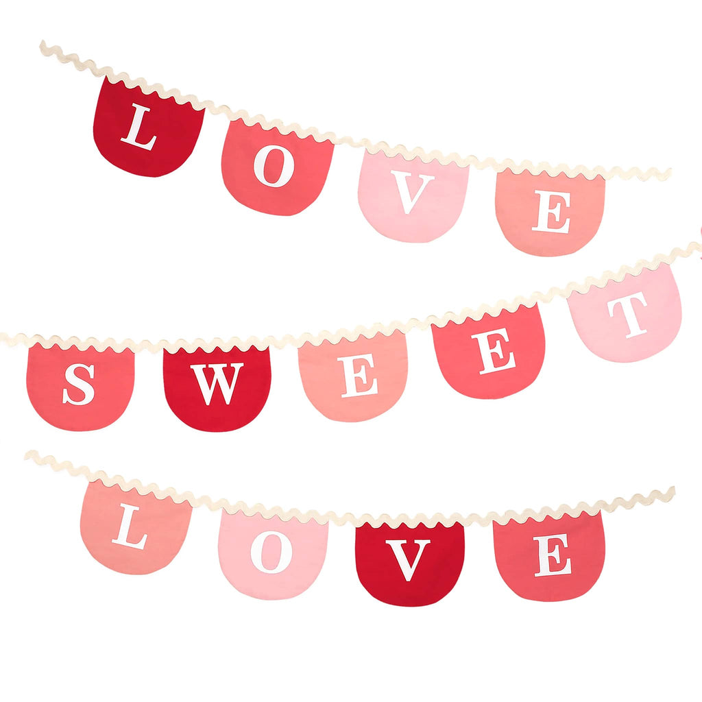 Meri Meri Valentines Fabric Garland with "Love sweet love" spelled out in letter pennants in shades of red and pink and mounted on cream ricrac, full length shown folded.