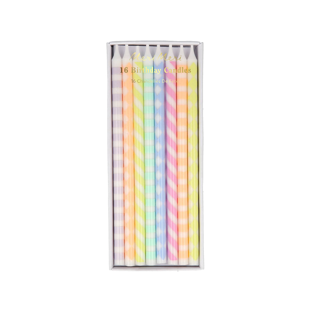 Pack of pastel-colored birthday candles with patterns in a clear box on a white background.