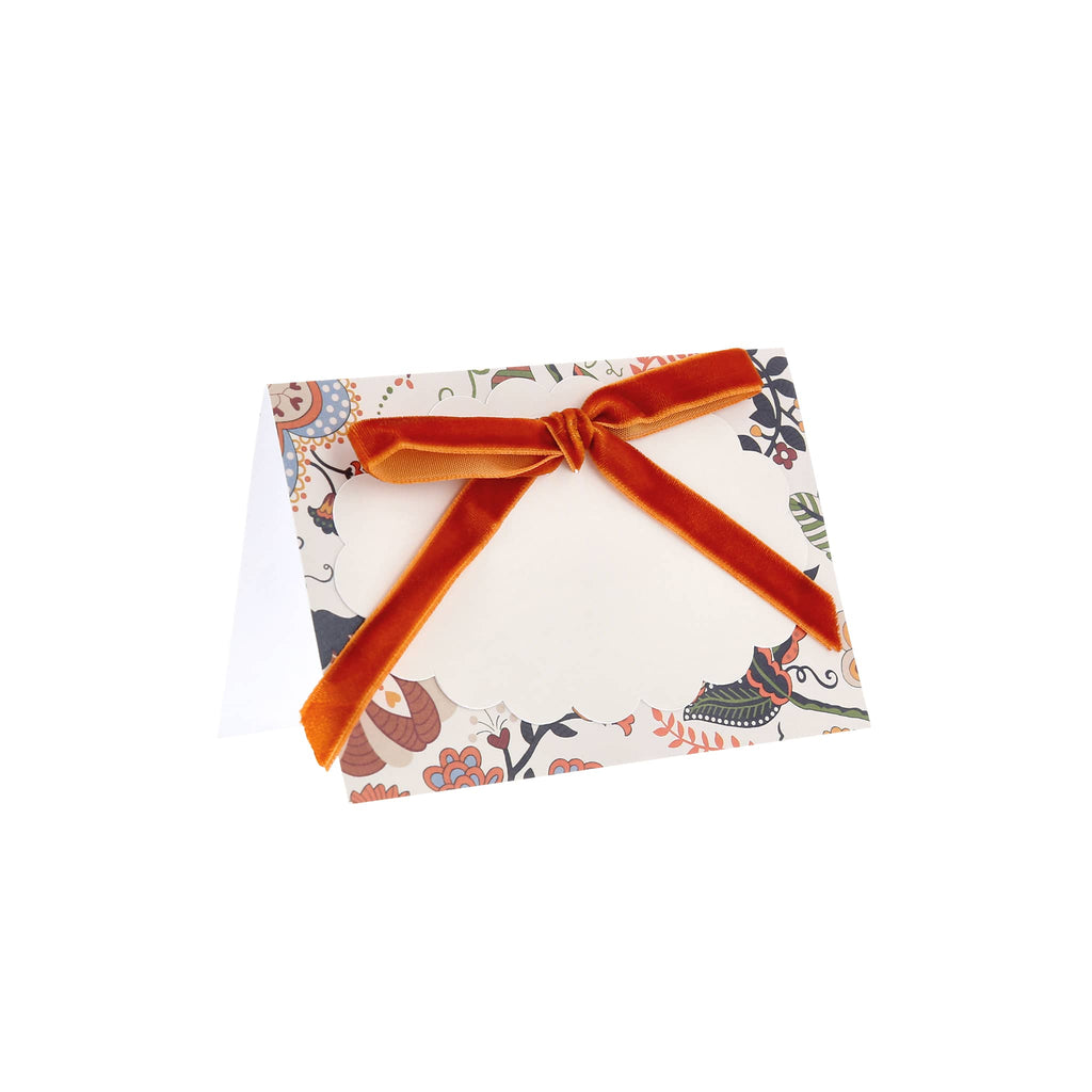 Tented floral place cards with dark orange velvet ribbon.