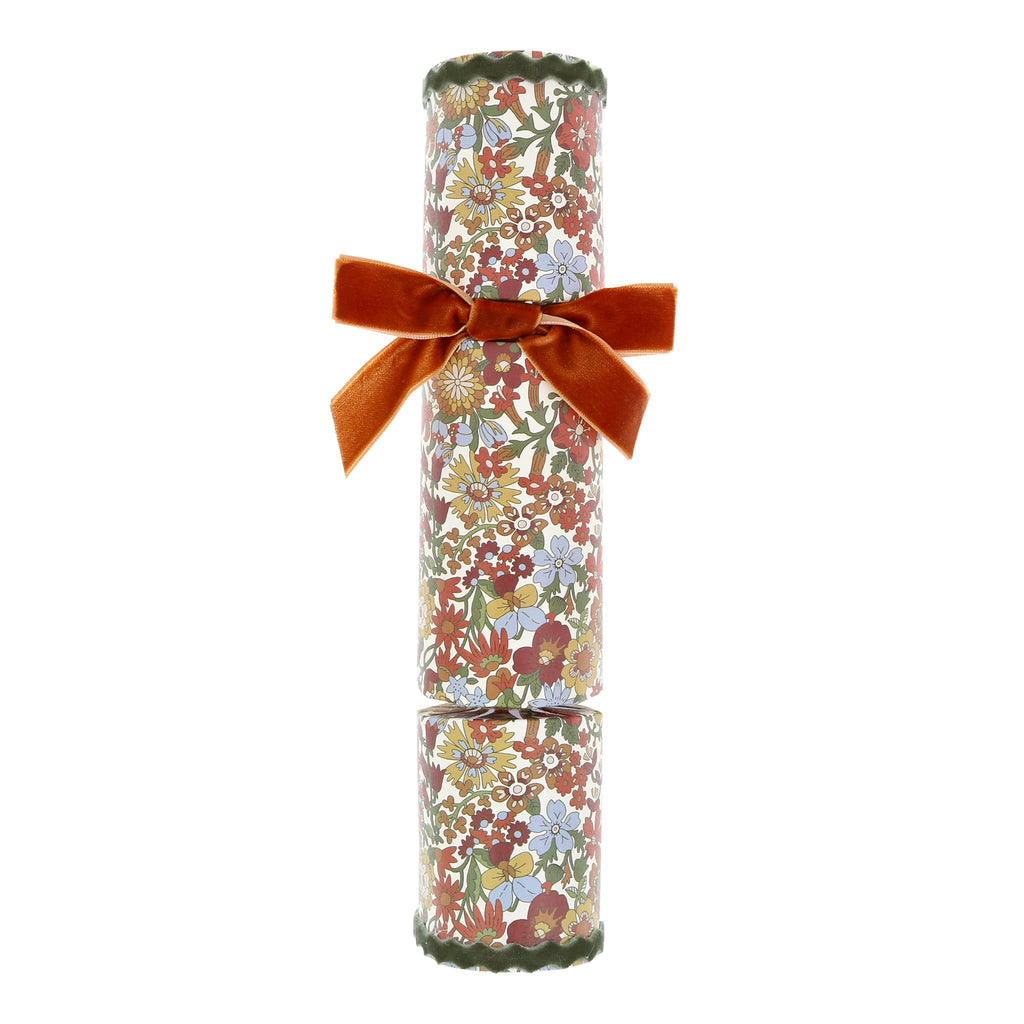 Floral-patterned cracker with a rust red velvet bow on a white background.