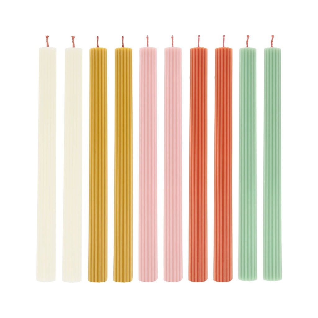 Set of ten colorful ridged table candles arranged in a row on a white background.