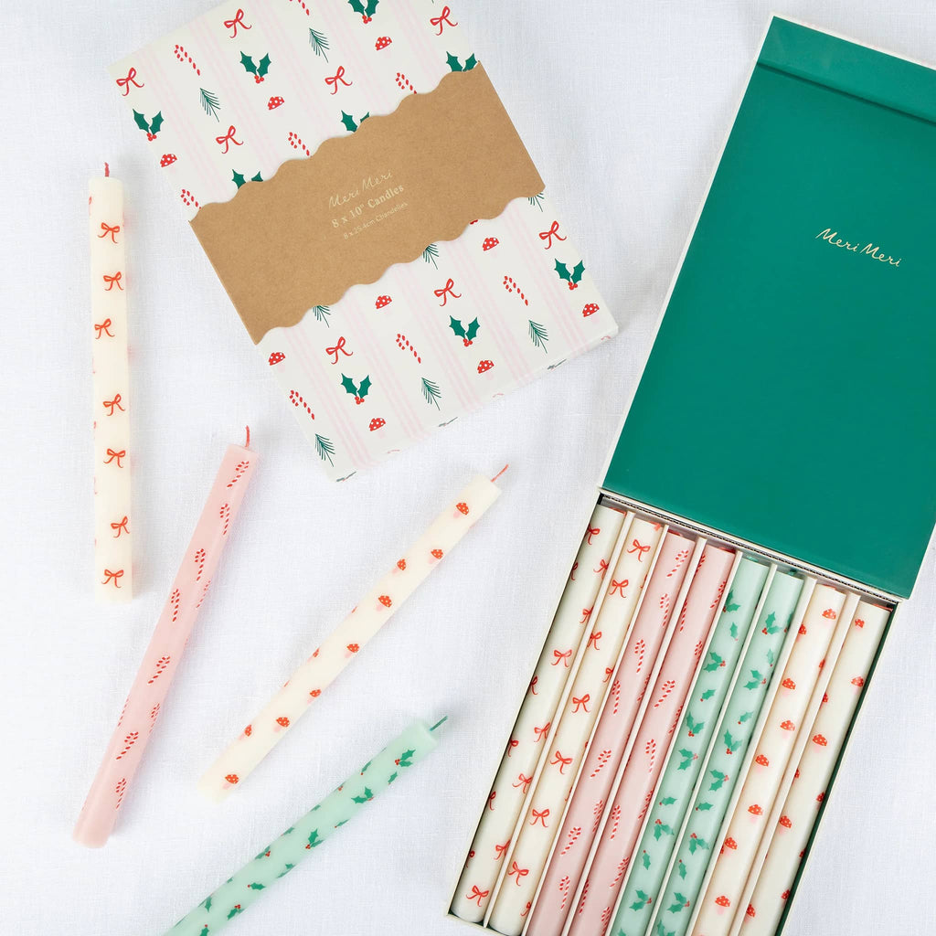 Set of decorative holiday-themed candles in and beside box packaging, on a white background.