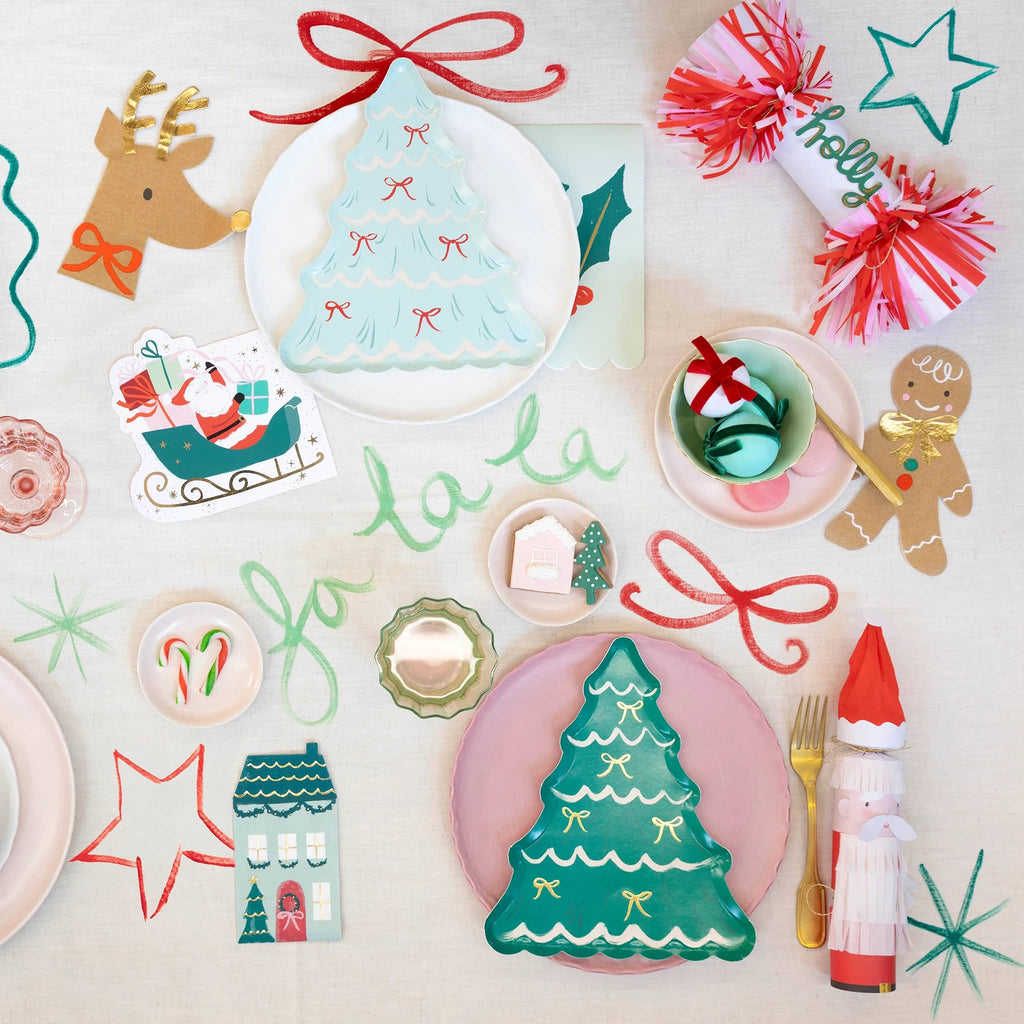 Colorful Christmas-themed table settings on a white background.