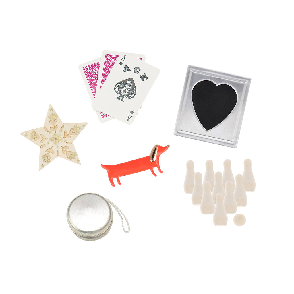 Collection of small items including playing cards, a star-shaped object, a dachshund figure, a heart-shaped container, and small bottles on a white background.