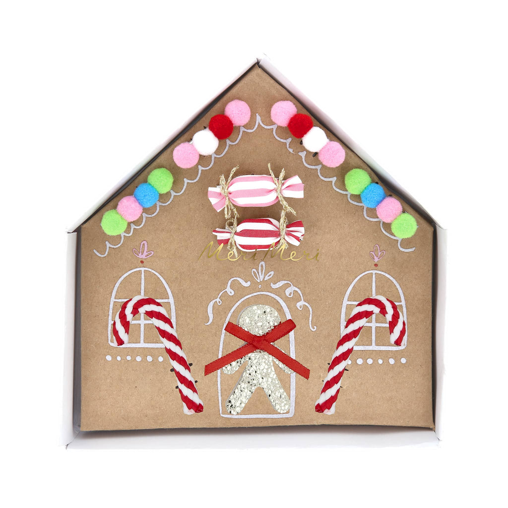 Christmas candy-themed hair clips in gingerbread house box packaging, on a white background.