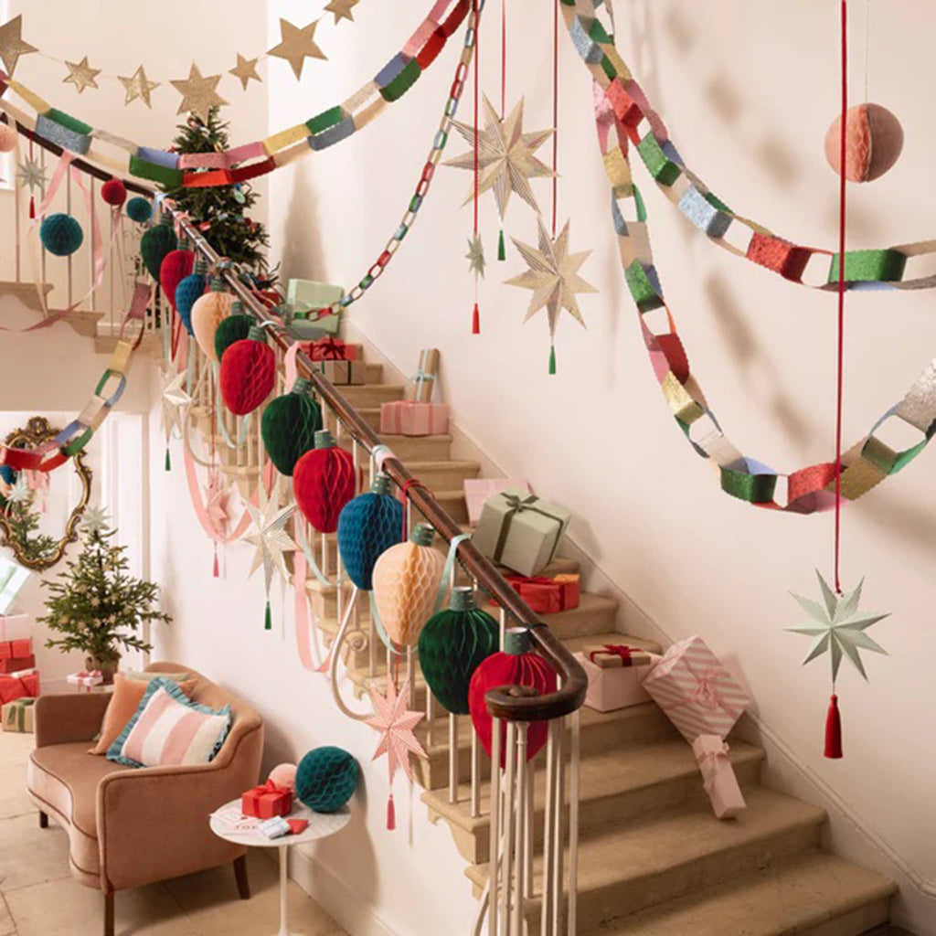 Decorative staircase with colorful honeycomb string lights, paper chains and star decorations.