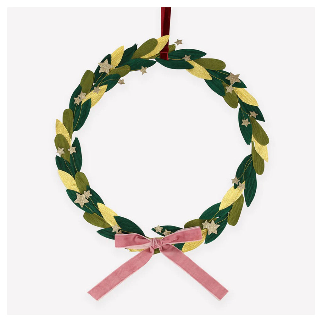 Meri Meri Paper Leaf & Star Wreath with crepe paper leaves in gold, dark green and mid-green layered on a metal hoop with glittery gold stars attached with wire, a dusty pink velvet bow and a red velvet ribbon for hanging.