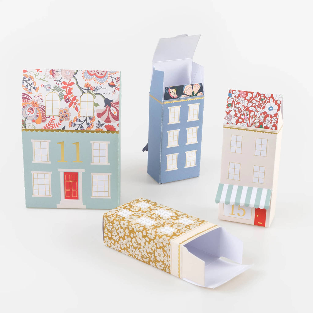 Colorful paper gift boxes with house designs on a white background.