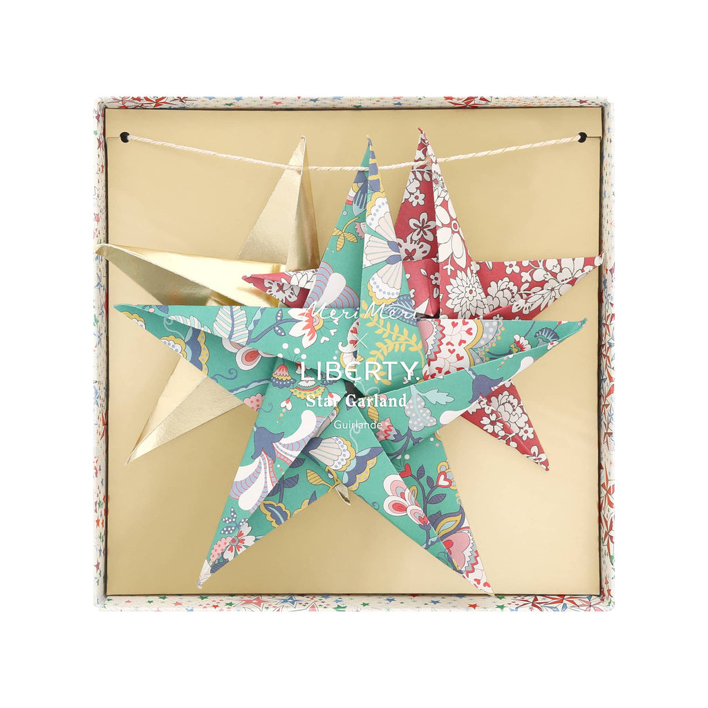 Colorful star-shaped origami decorations with floral prints in a Liberty box on a white background.