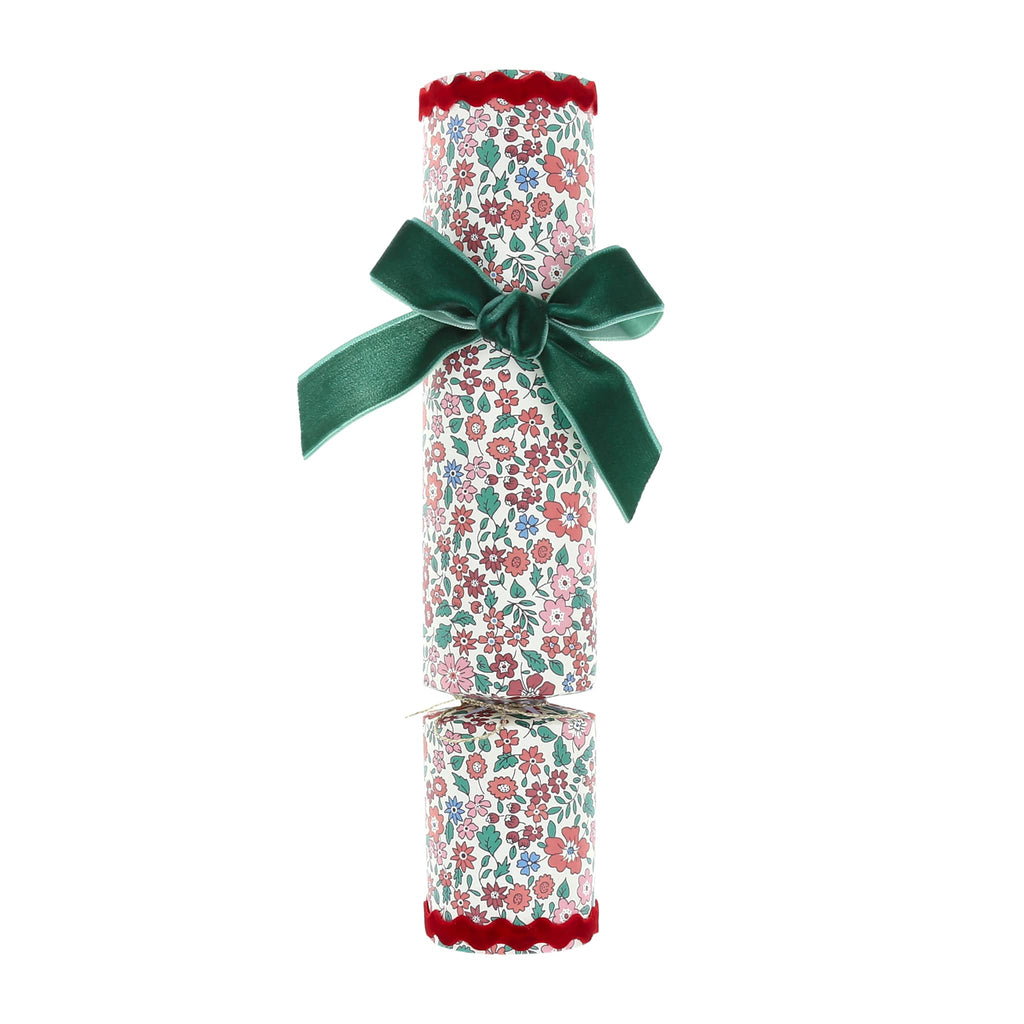 Party cracker with floral print and dark green velvet bow, on a white background.