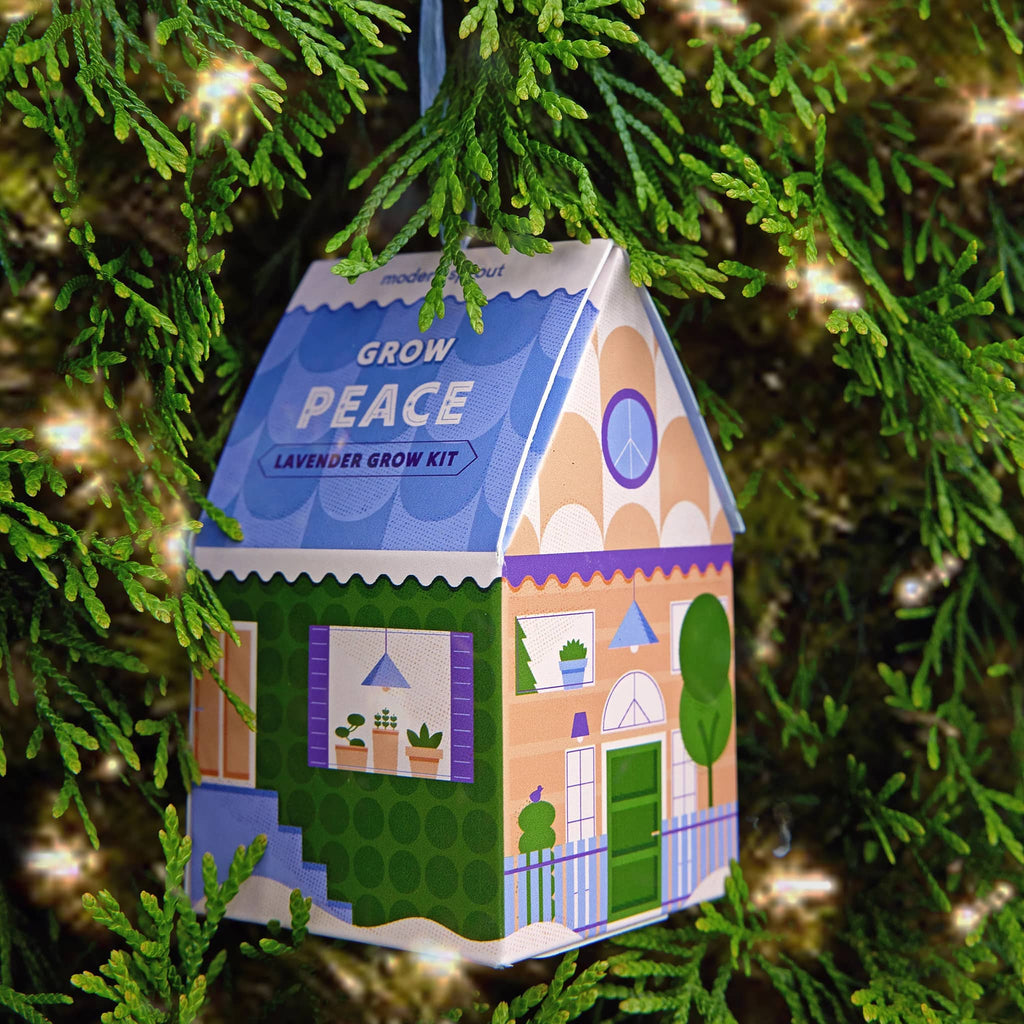 Modern Sprout Home Grown Ornament in Grow Peace, Lavender grow kit in house-shaped box ornament with raffia  hanger, on a tree.