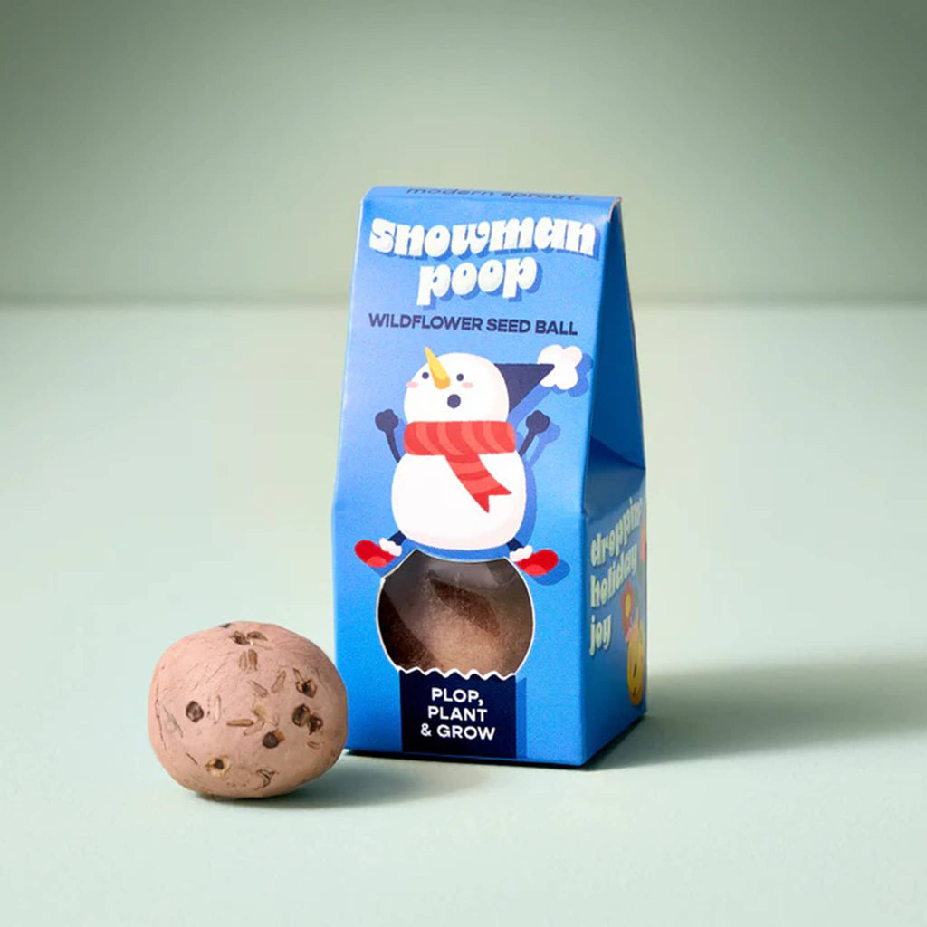 Snowman poop wildflower seed ball with packaging on a light green background.