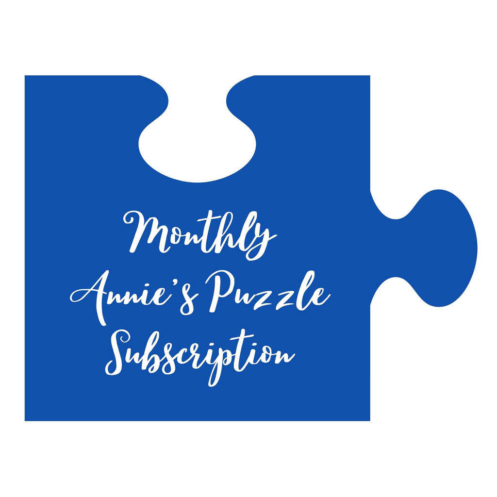 An illustration of a blue puzzle piece with "monthly annie's puzzle subscription" in white lettering.