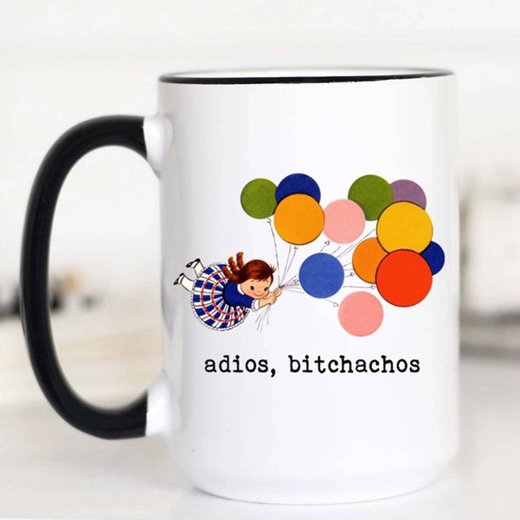 Mugsby white ceramic mug with black handle and rim with a vintage-inspired illustration of a girl being carried away by a bunch of balloons  and "adios, bitchachos" in black lettering.