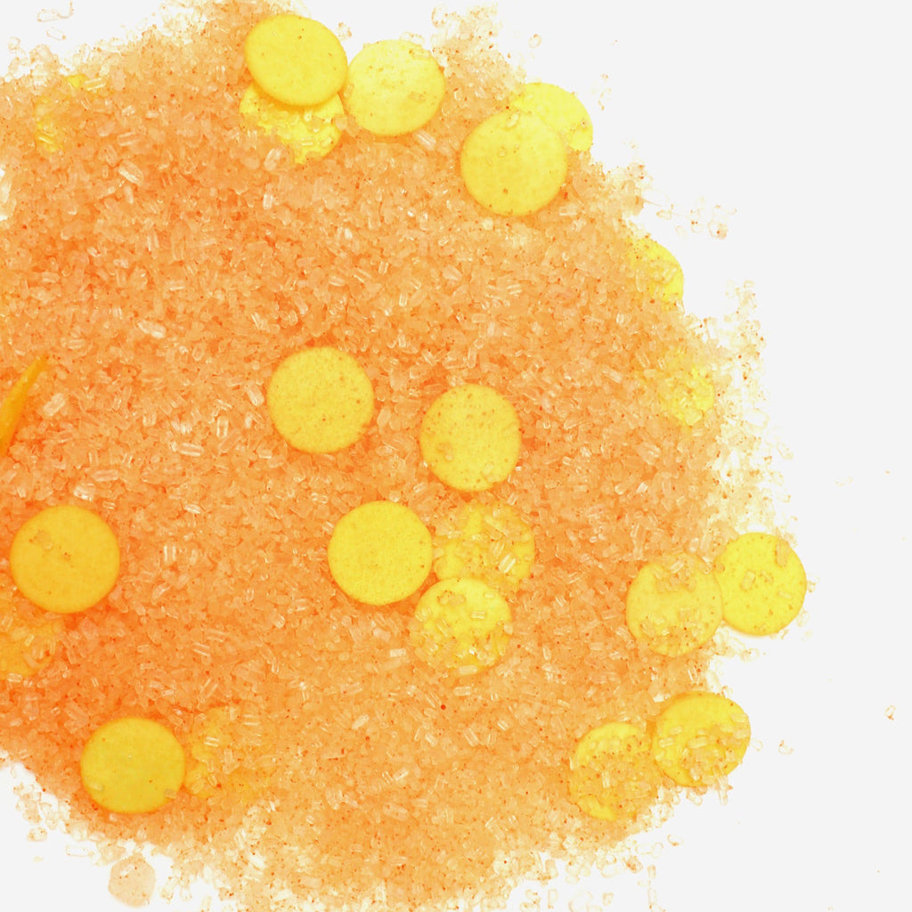 Musee Bath Don't Worry Be Happy bubbly bath soak with orange salt crystals and yellow soap paper confetti.