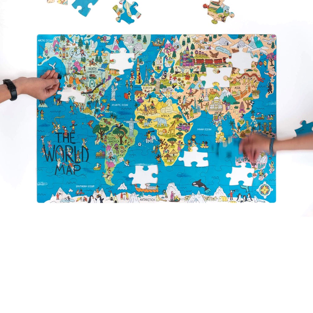 Nolja Play 100 piece Wonderful World jigsaw puzzle in progress with hands placing pieces.