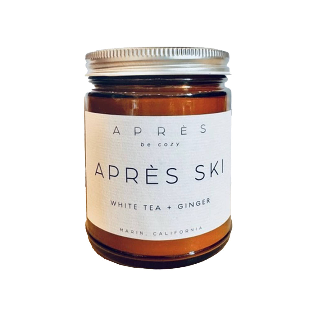 Amber candle jar labeled 'Apres Ski' with white label on a white background.