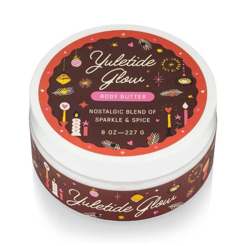 Yuletide Glow body butter container with festive design on a white background.