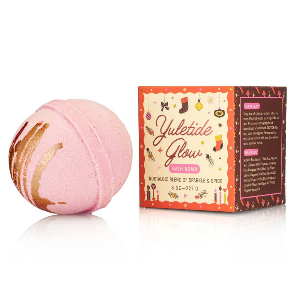 Pink bath bomb with 'Yuletide Glow' packaging on a white background.