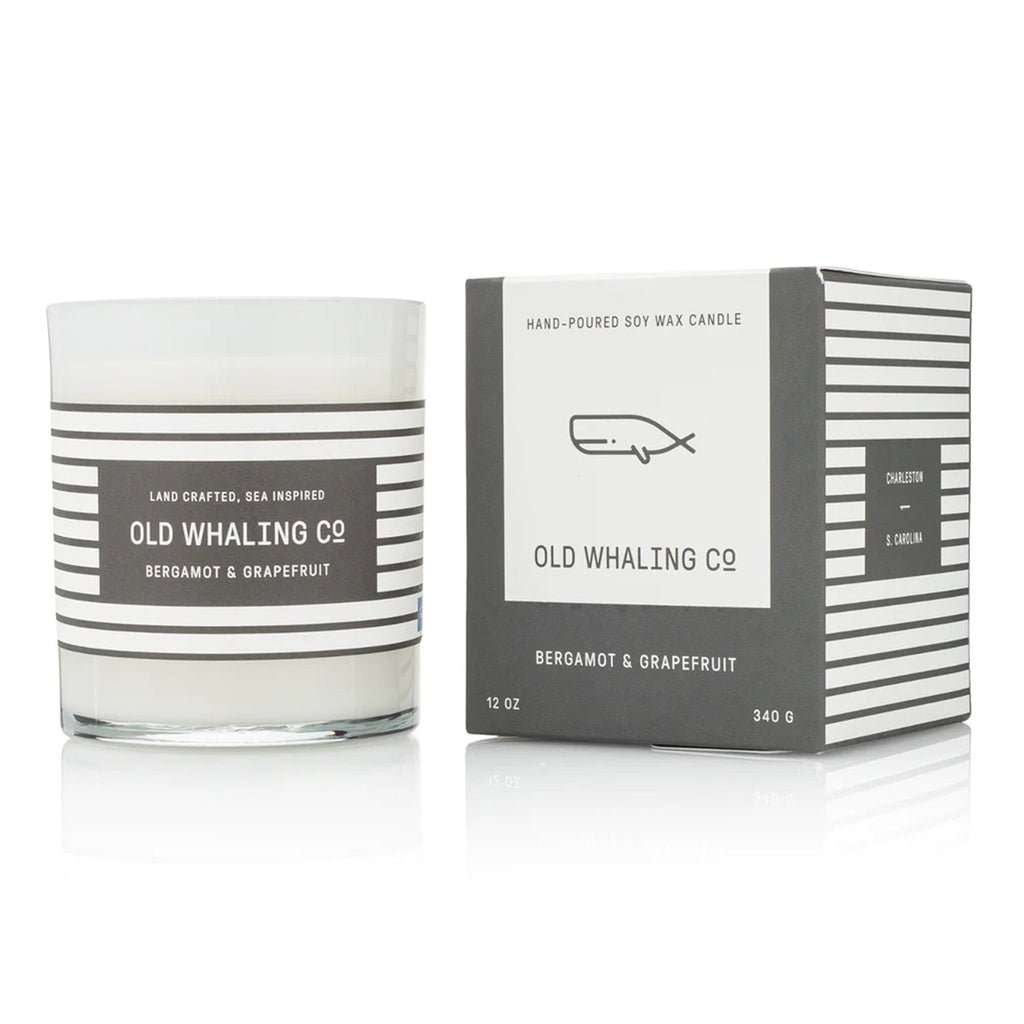Old Whaling Company Bergamot & Grapefruit 12 ounce scented olive oil and soy wax blend candle in an opaque white glass vessel with gray and white striped label beside matching gray gift box.