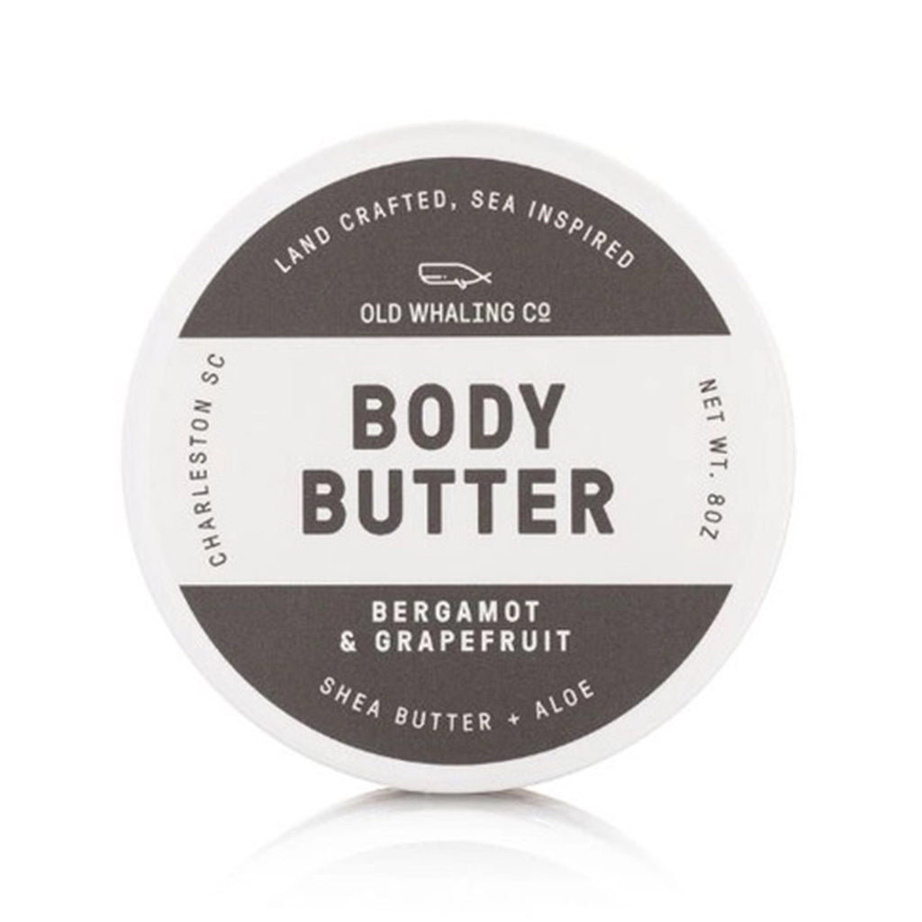Old Whaling Company Bergamot and Grapefruit scented body butter with shea butter and aloe in white and gray ounce tub, top view.
