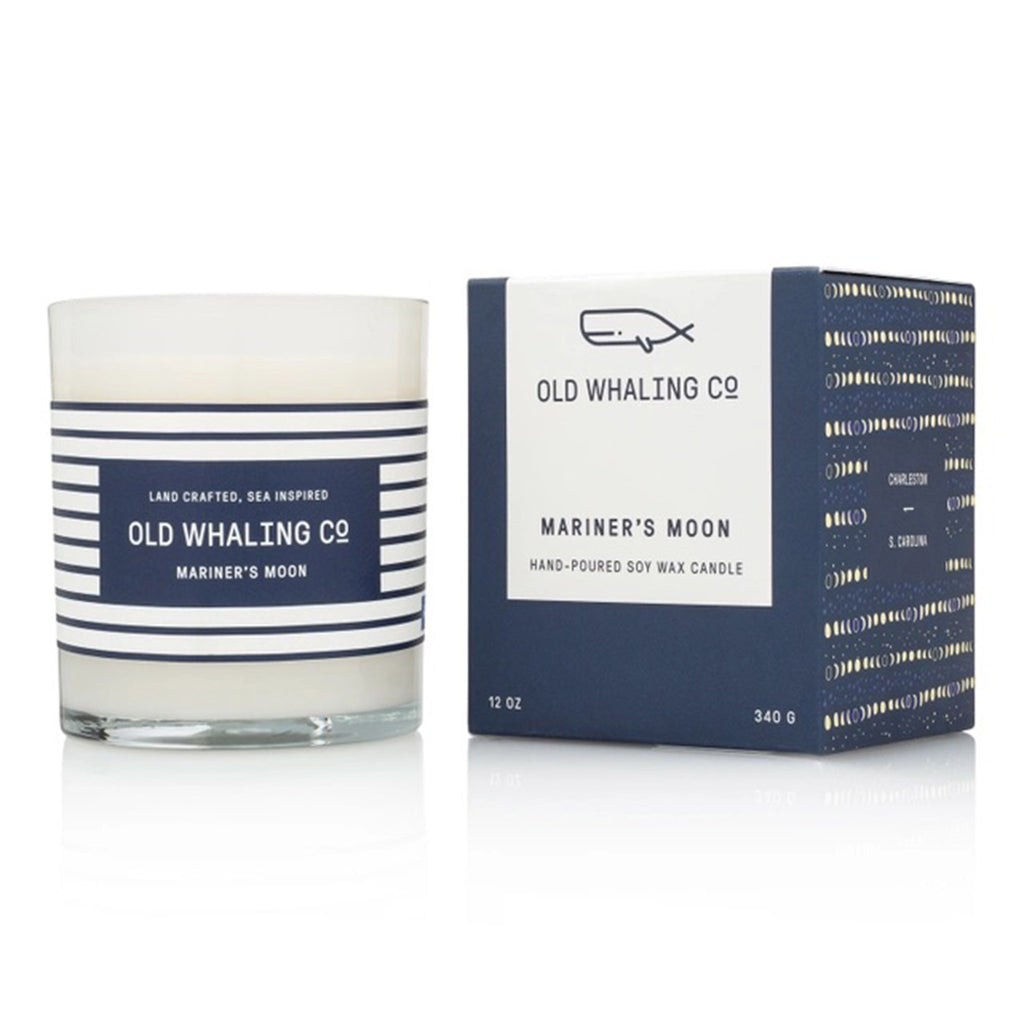 Old Whaling Company Mariners Moon 12 ounce scented olive oil and soy wax blend candle in a milky white glass vessel with navy and white striped label beside matching navy blue gift box.