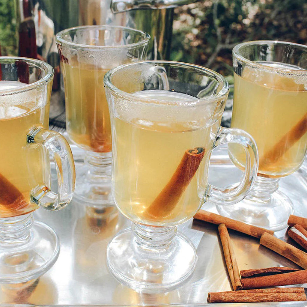 Oliver Pluff Orange Clove Hot Toddy cocktail in glasses with cinnamon sticks.
