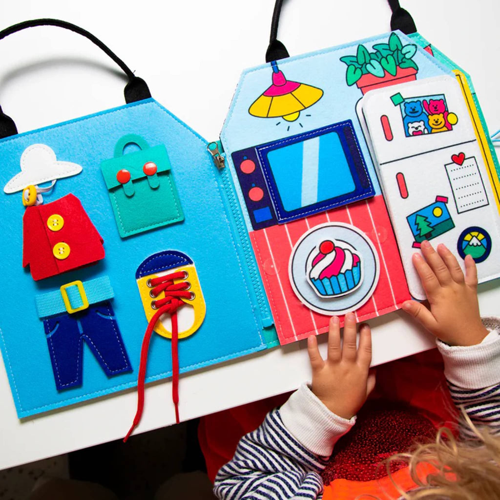 Children's educational felt board with various interactive elements, being used by a child.