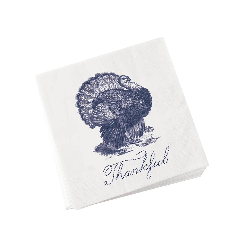 Stack of white paper napkins with a blue turkey illustration and 'Thankful' text on a white background.