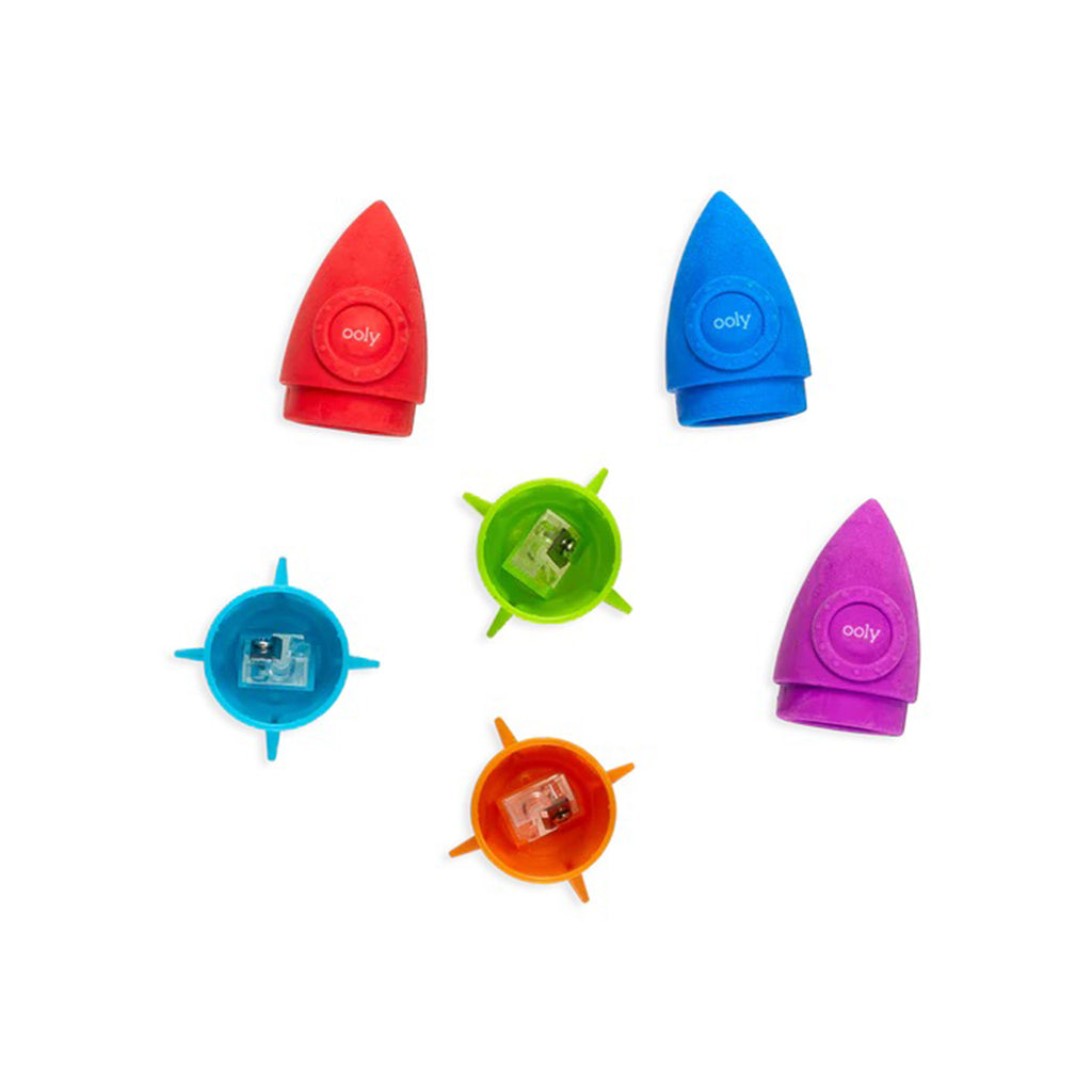 Ooly Blast Off rocket shaped pencil eraser and sharpener in 3 color combinations, eraser is separated from sharpener, overhead view into sharpener.