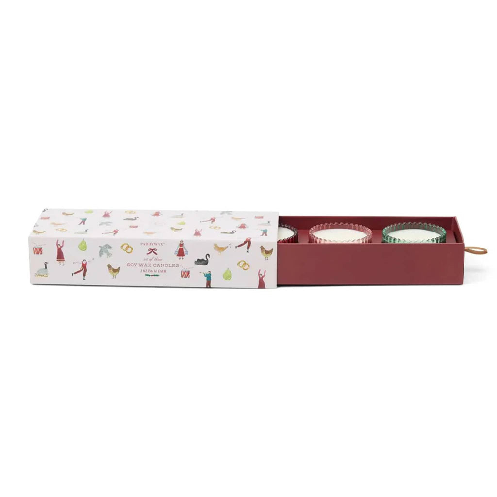 Set of candles in a decorative box with holiday illustrations on a white background.